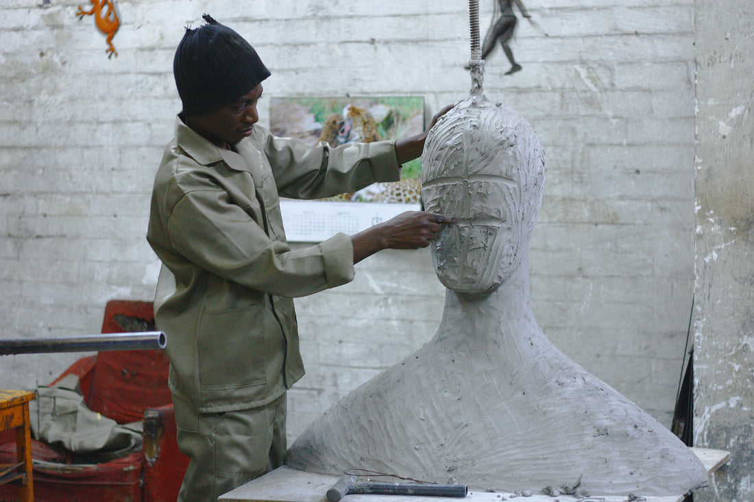 artist works on figurative clay sculpture in studio for commission from art agency