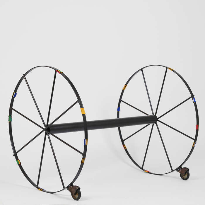 Dreams on Hold, 2024, wheels, steel and kente, 19 x 19 x 25 in. / 48.26 x 48.26 x 63.5 cm.