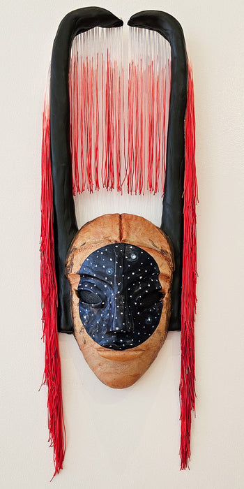 The Weight of Becoming Mask, 2025, mixed media, 28 x 9 x 4.5 in. / 71.12 x 22.86 x 11.43 cm.