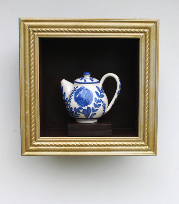 Blue Garden Teapot, 2025, porcelain teapot in wooden frame, 14 x 14 x 6 in. / 35.56 x 35.56 x 15.24 cm.