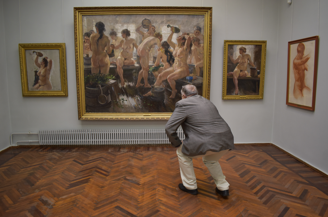 an art conservator closely examines oil paintings