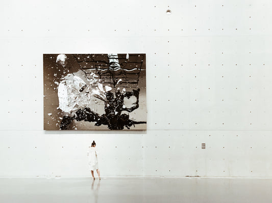 artist stands with artwork in white cube gallery