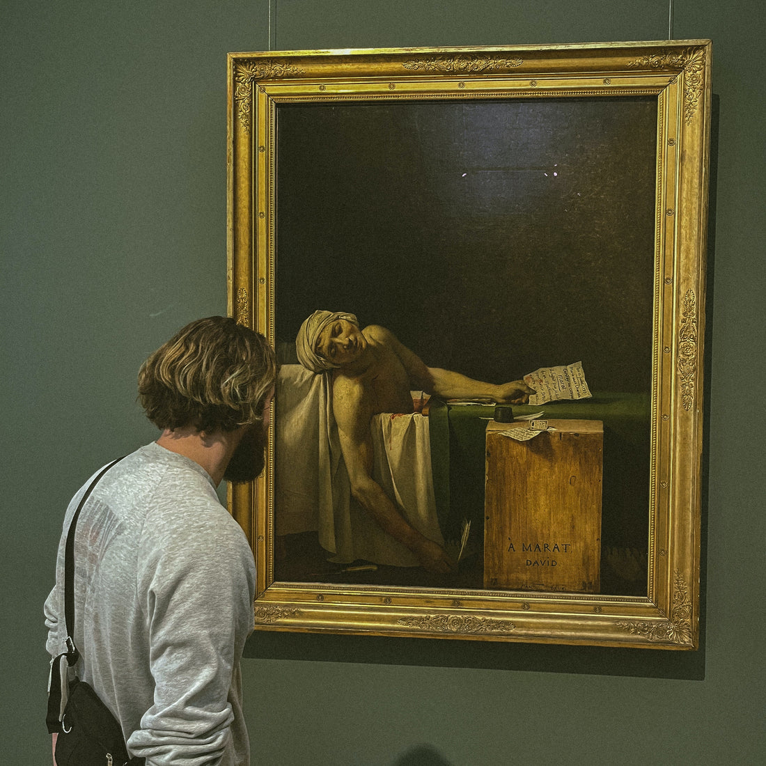 man closely examines the death of marat