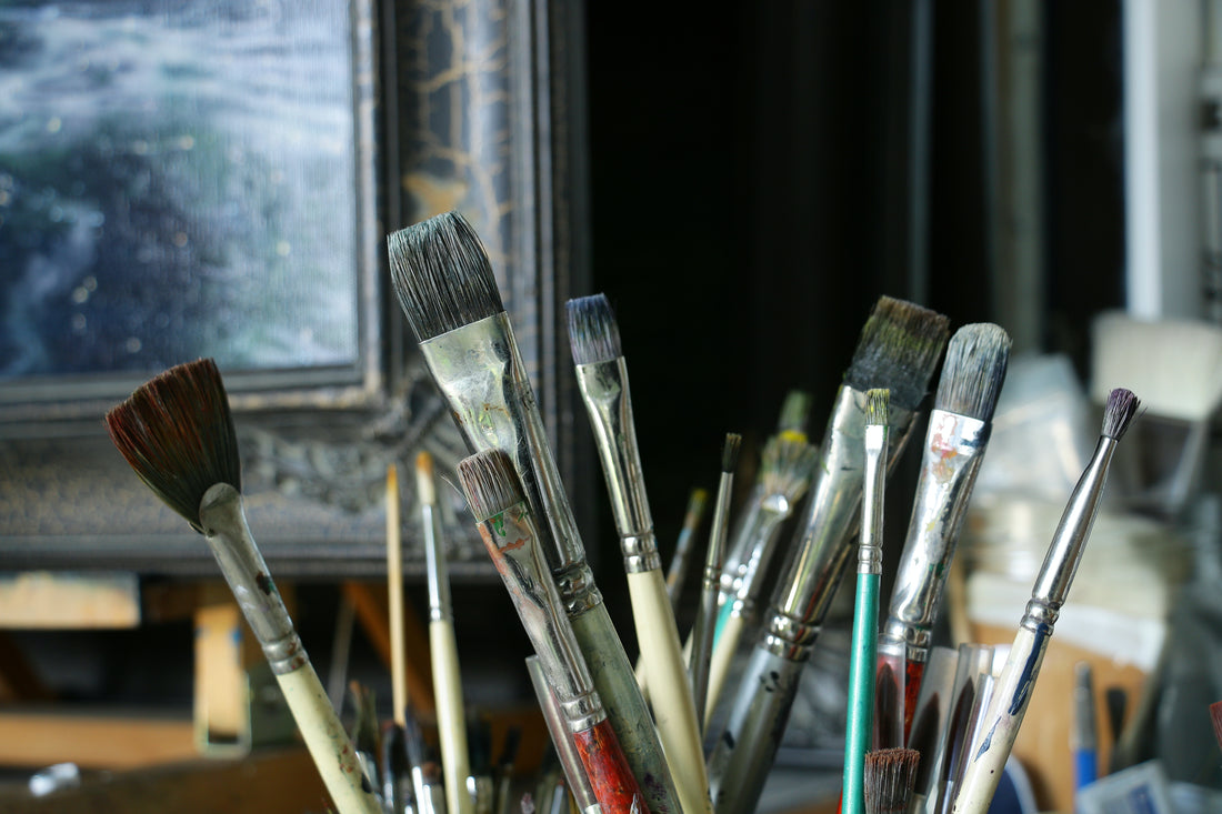 oil paint brushes with oil painting in background