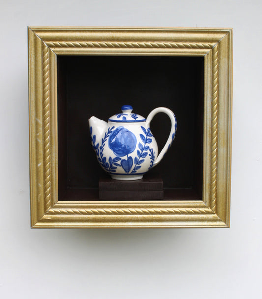 Blue Garden Teapot, 2025, porcelain teapot in wooden frame, 14 x 14 x 6 in. / 35.56 x 35.56 x 15.24 cm.